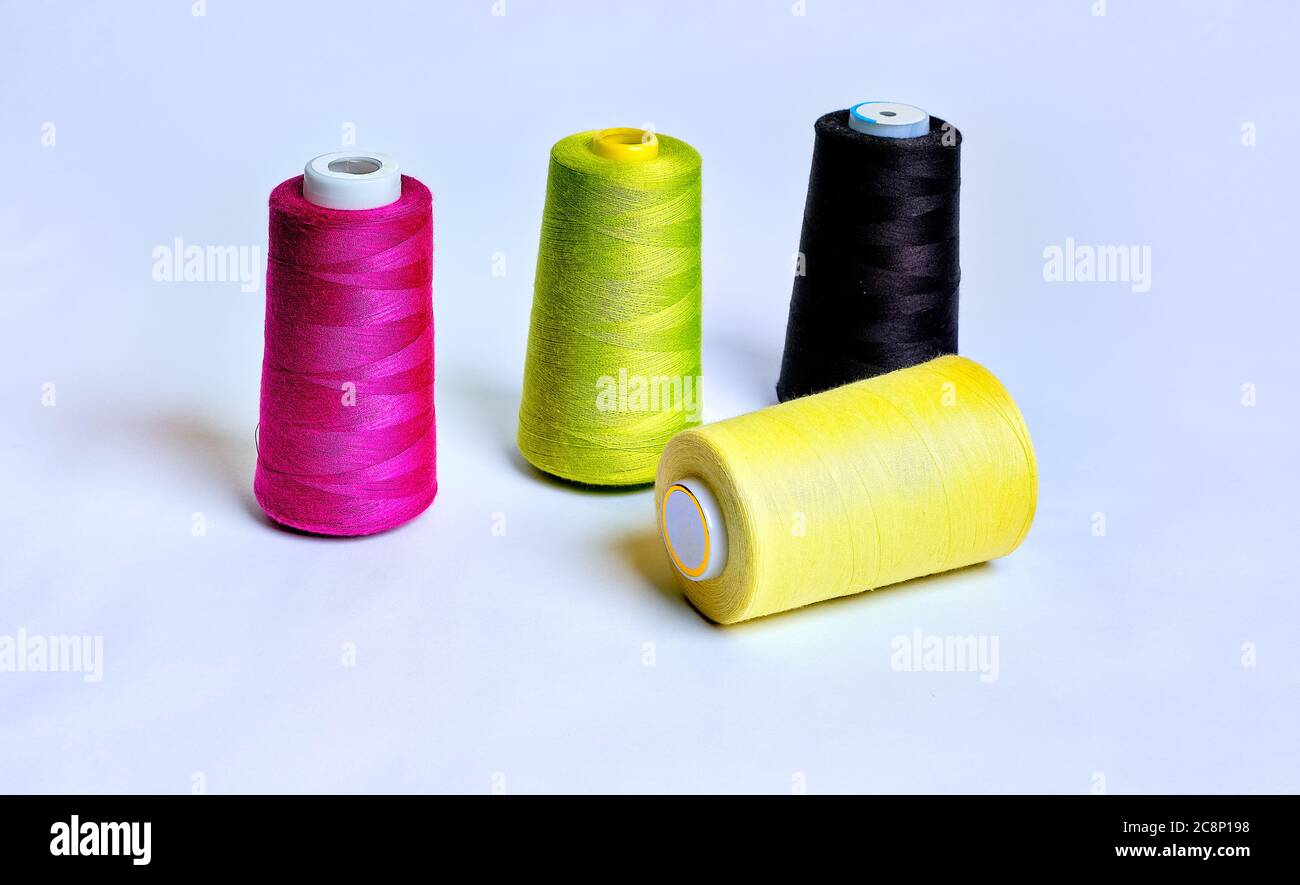 Four sewing thread rolls in different colors isolated on white Stock Photo