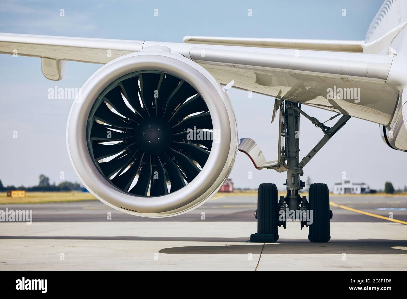 Jet engine of commercial airplane at airport during sunny day. Themes modern technology, power and travel. Stock Photo