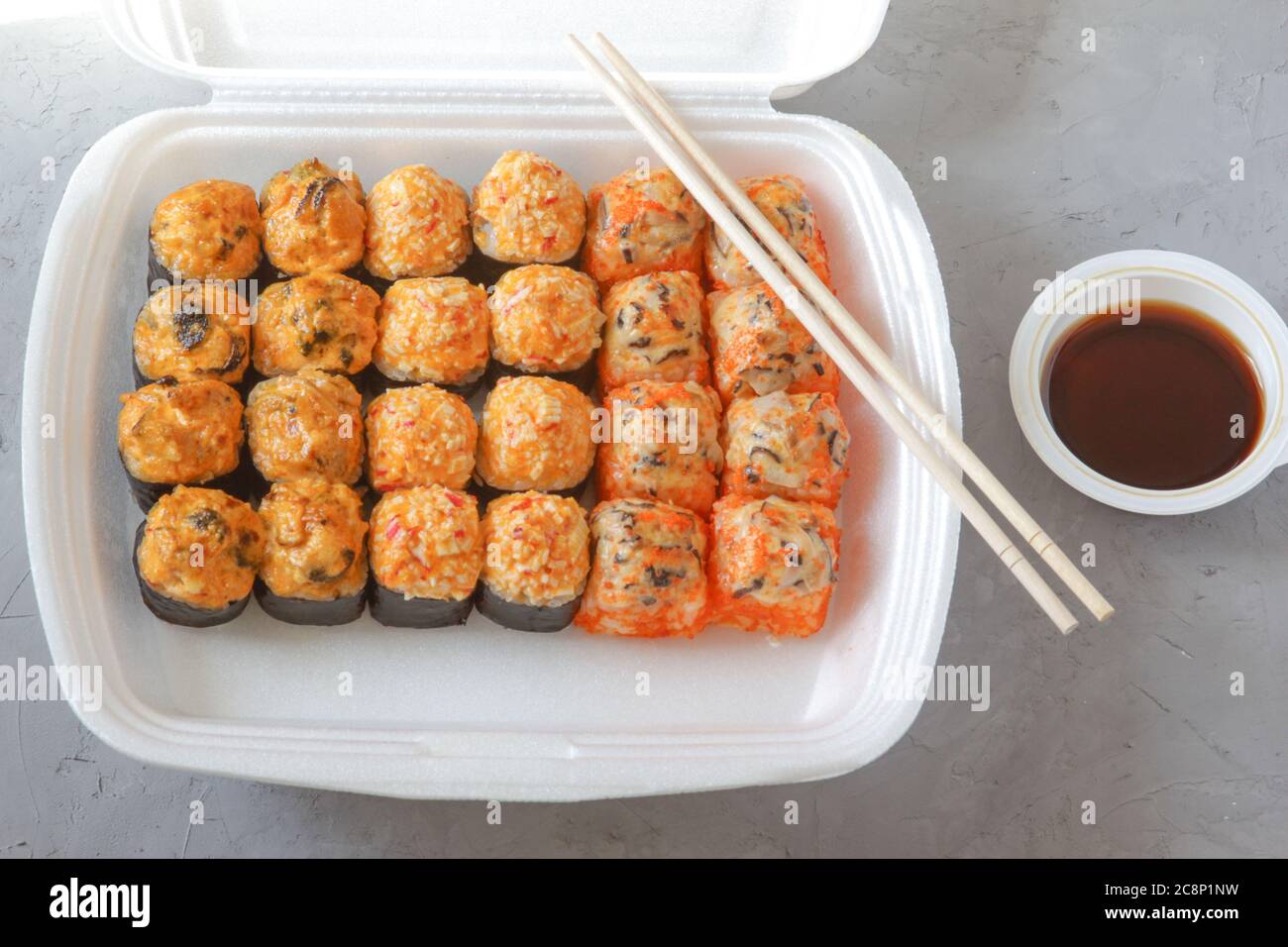 Set Japanese sushi with soy sauce and chopsticks on a grey concrete background. Restaurant food delivery. Top view. Stock Photo