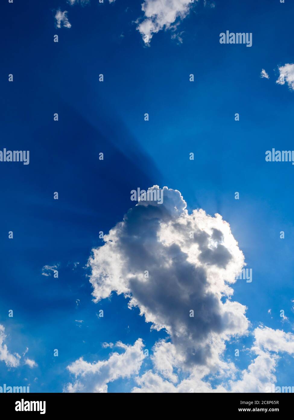 Dark Blue sun rays sunrays near behind White clouds cloud view against sky sunshine sunlight sunny Stock Photo