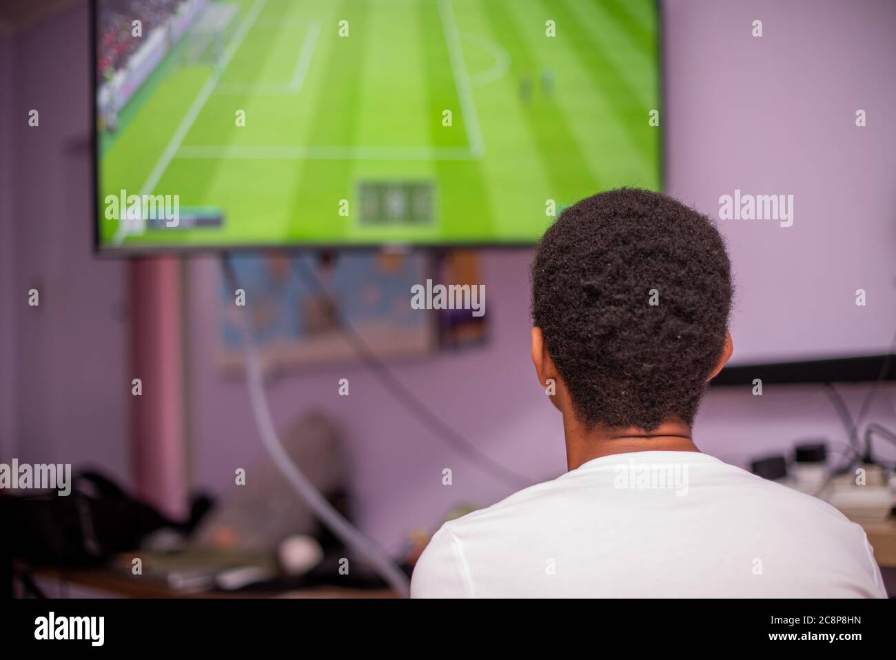 Young boy shot from behind while playing games Stock Photo