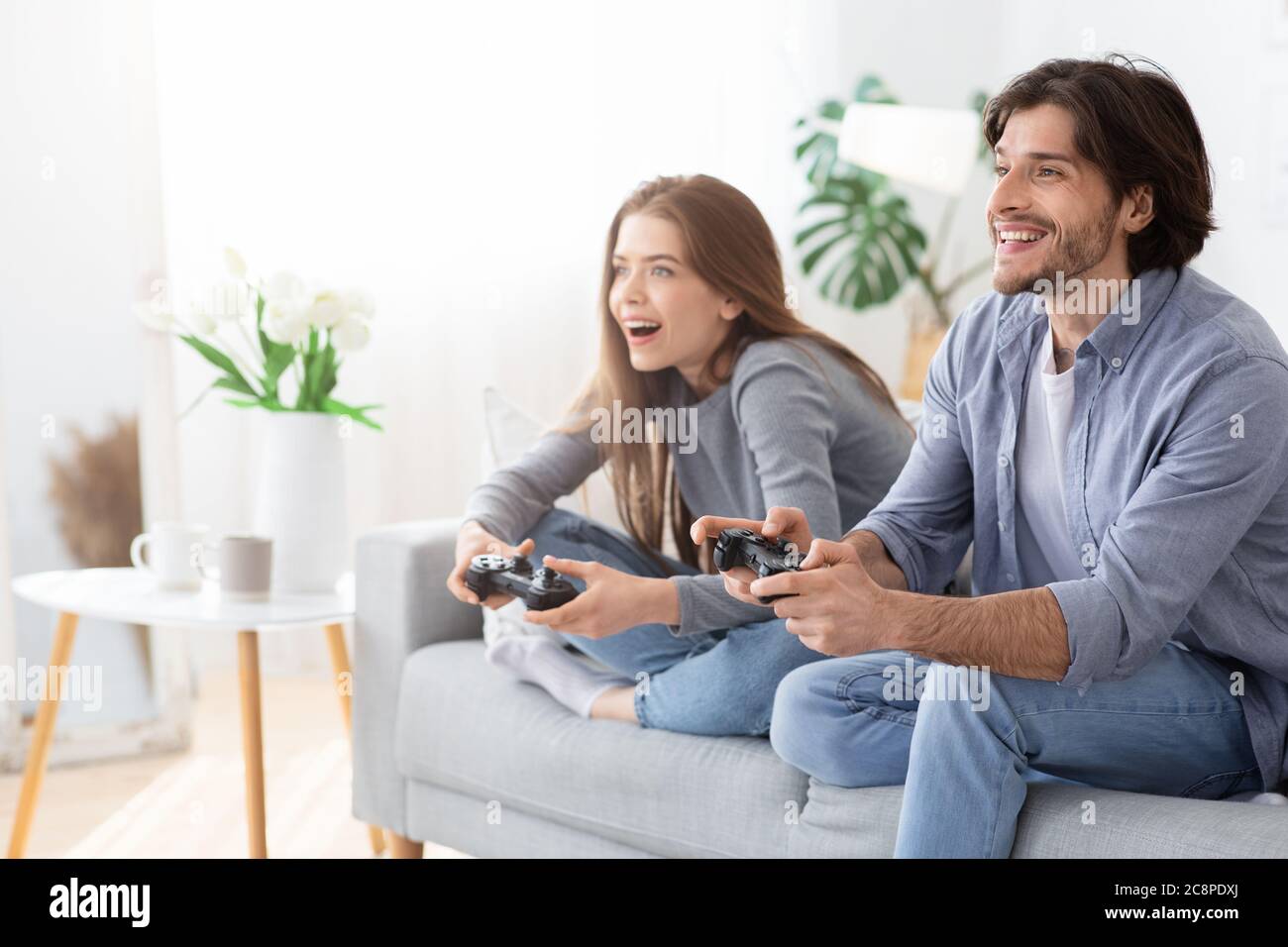 Excited man and woman playing video games at home Stock Photo