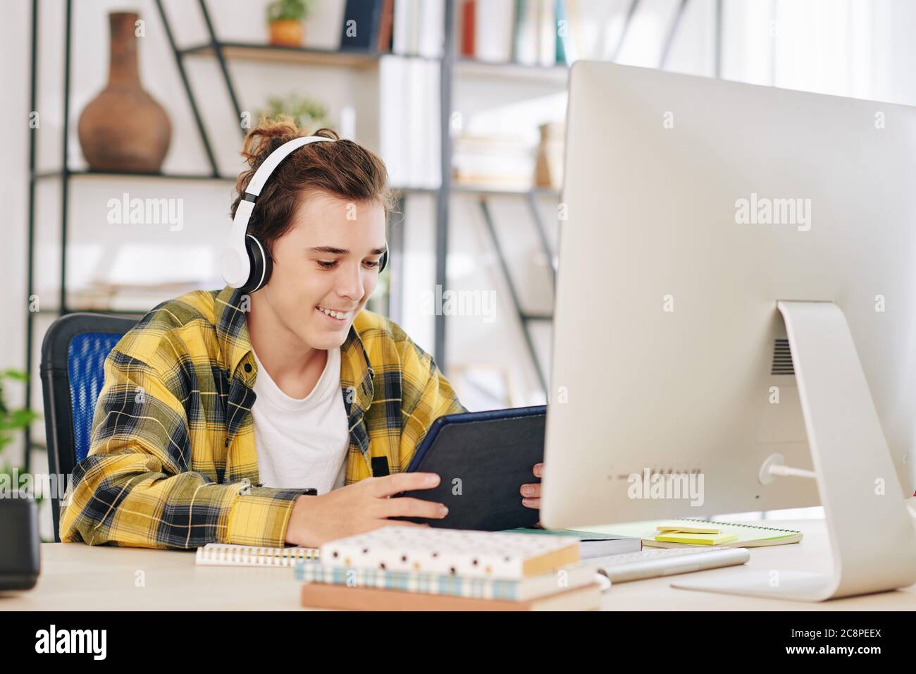 Boy doing homework and watching tv hi-res stock photography and images ...