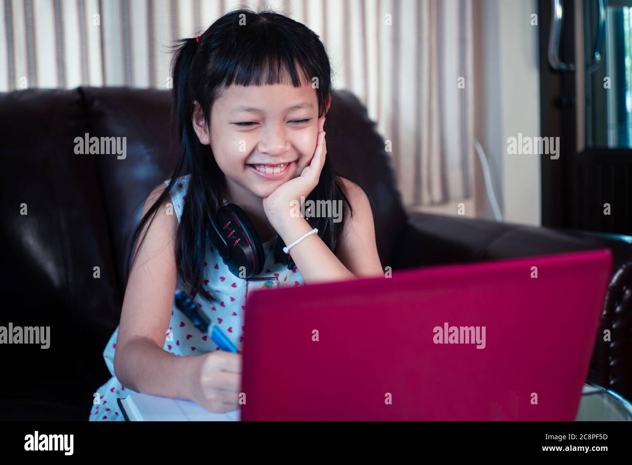 Little child girl  learning on laptop at home,Social distance during quarantine, Online education concept Stock Photo