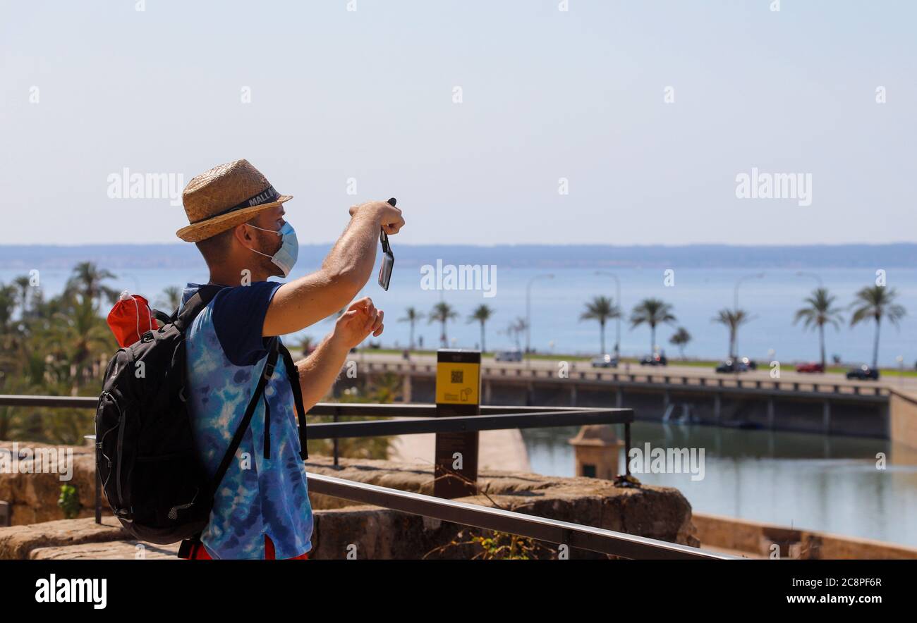 Palma, Spain. 26th July, 2020. Alex from London photographs the old city walls of Palma. Thousands of British people have to go into a two-week quarantine after their summer holiday in Spain. The British Minister of Transport Shapps is also directly affected: The minister is in Spain with his family, his spokesman for the German Press Agency confirmed on Sunday. The quarantine obligation applies not only to the Spanish mainland, but also to returnees from the Balearic and Canary Islands, the spokesman explained. Credit: Clara Margais/dpa/Alamy Live News Stock Photo