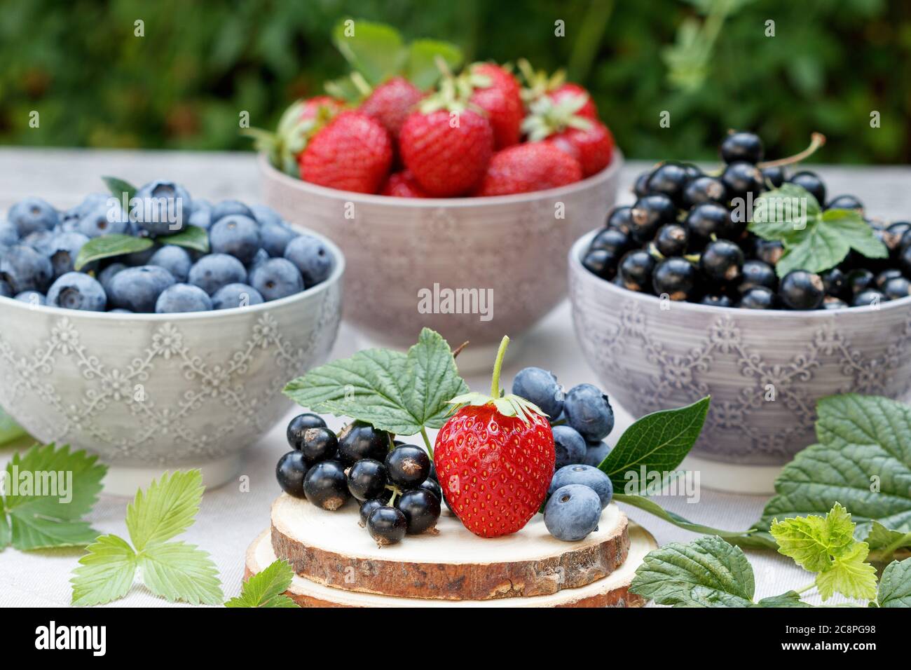 fresh mixed berries strawberry, blueberry and black currant in bowls Stock Photo