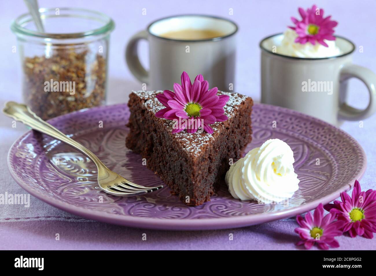 piece of chocolate cake on the plate and chrysanthemum flowers astable decoration Stock Photo