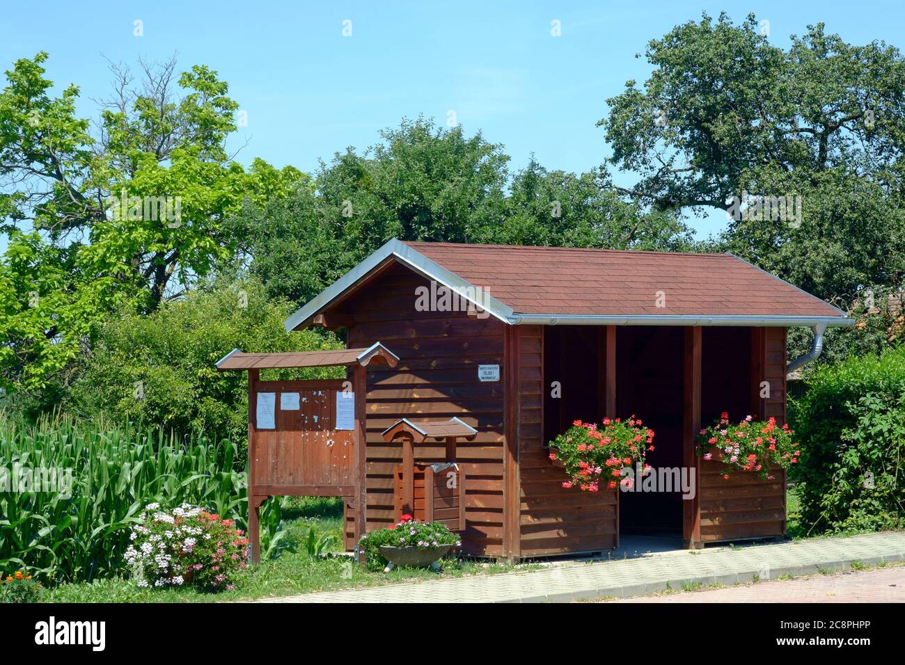 wooden bus shelter adorned with flowers in rural village zala county hungary Stock Photo
