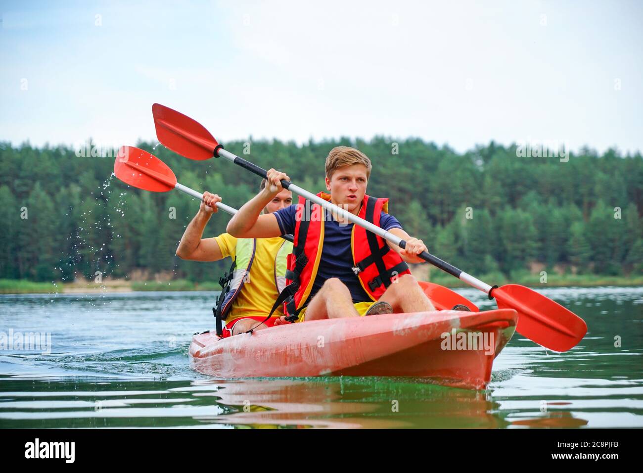 two guys in a red kayak on the river, in life jackets Stock Photo Alamy