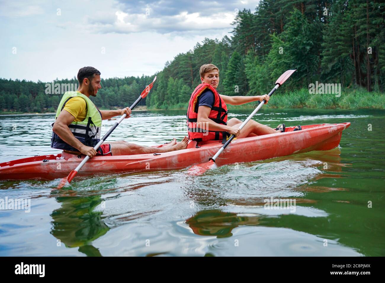 two guys in a red kayak on the river, in life jackets Stock Photo Alamy