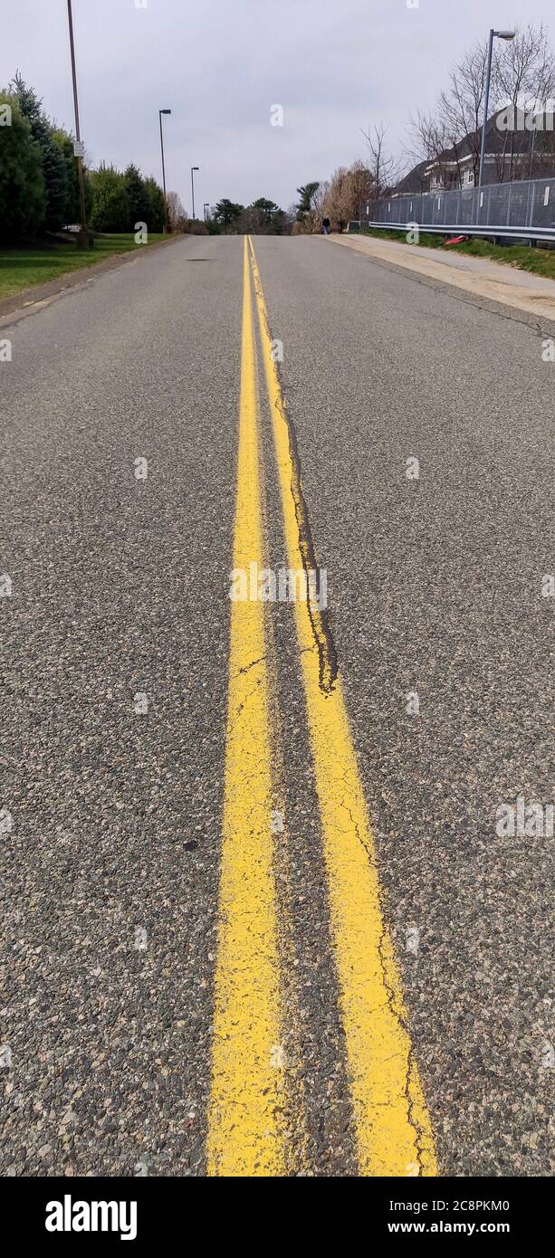 Yellow road dividers on a two lane street Stock Photo Alamy