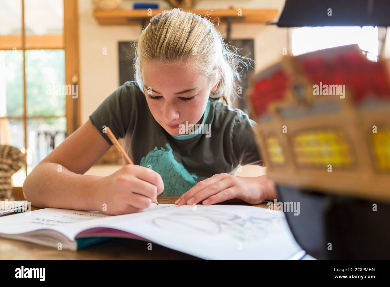 12 year old girl drawing in sketch pad at home Stock Photo