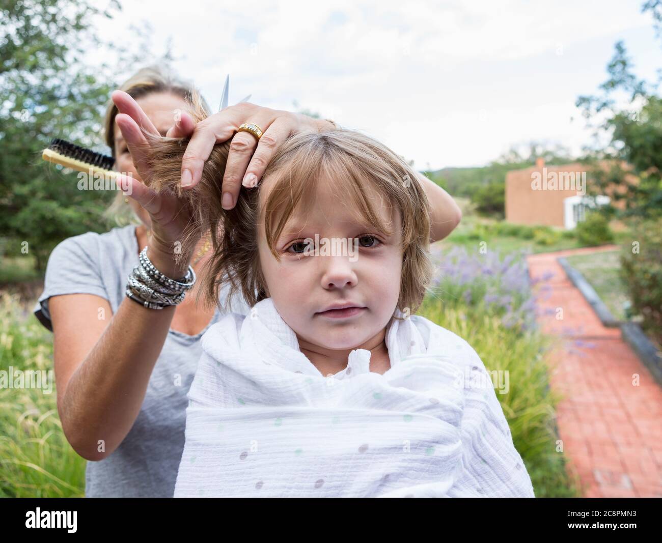 5-year-old-boy-getting-his-hair-cut-by-mother-outside-stock-photo-alamy