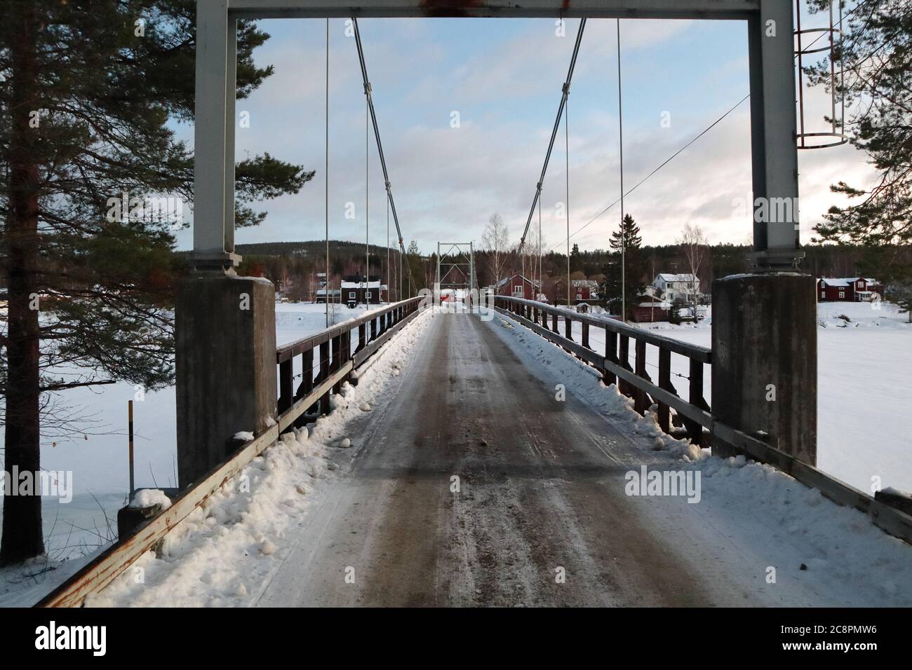 Bridge crossing frozen river in wintertime, Vindeln, Lapland, Sweden Stock Photo
