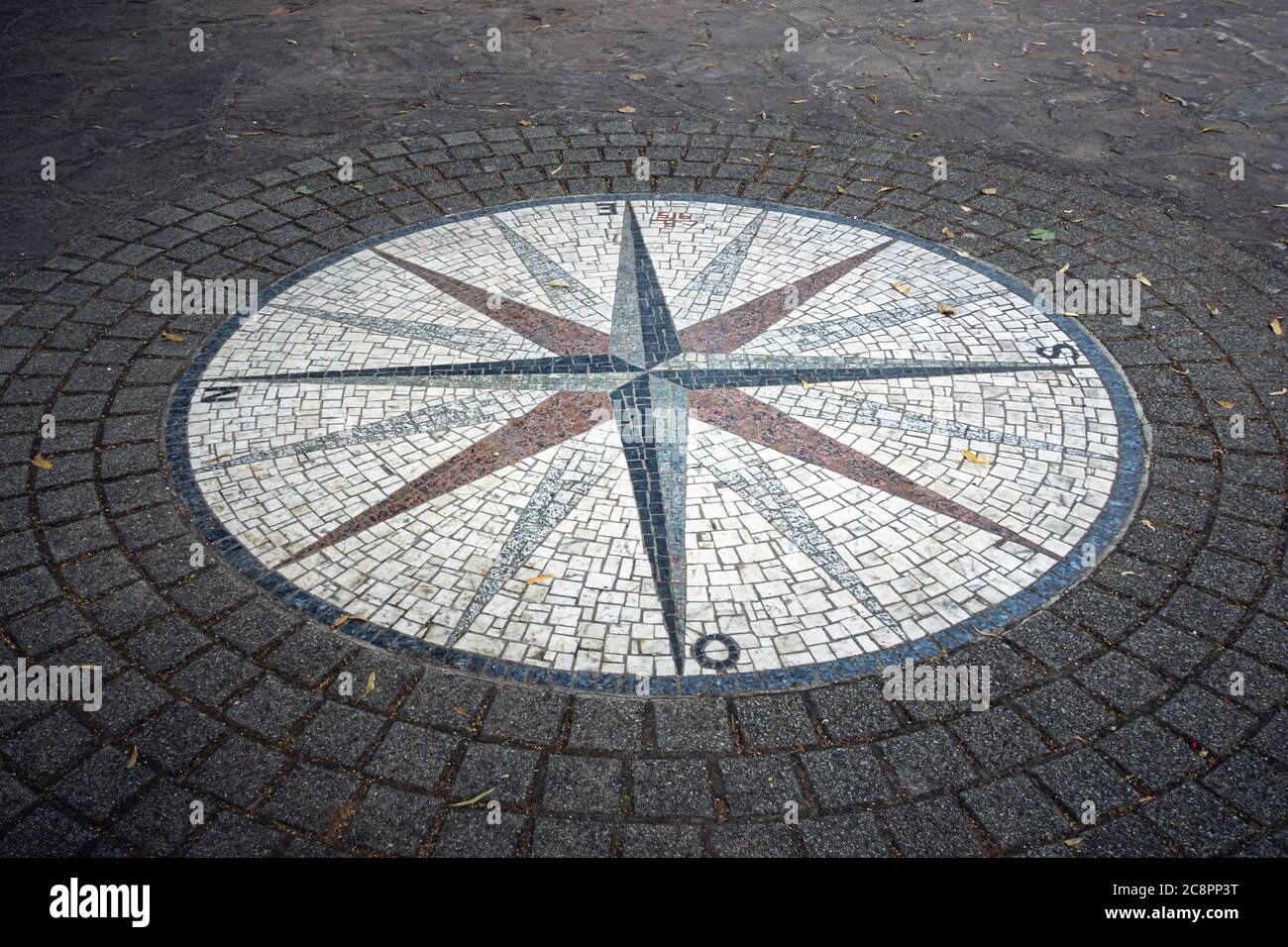 Mosaic compass rose on the floor surrounded by cobblestones Stock Photo
