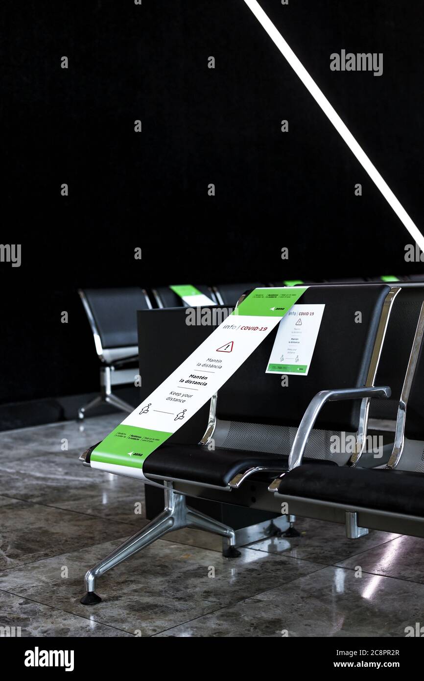 Covid-19 warnings placed on every other chair to ensure social distancing at Alicante Airport Stock Photo