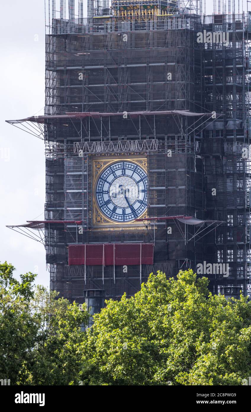 The clock face of Big Ben with the rest of the Queen Elizabeth Tower covered in scaffolding under renovation. Stock Photo