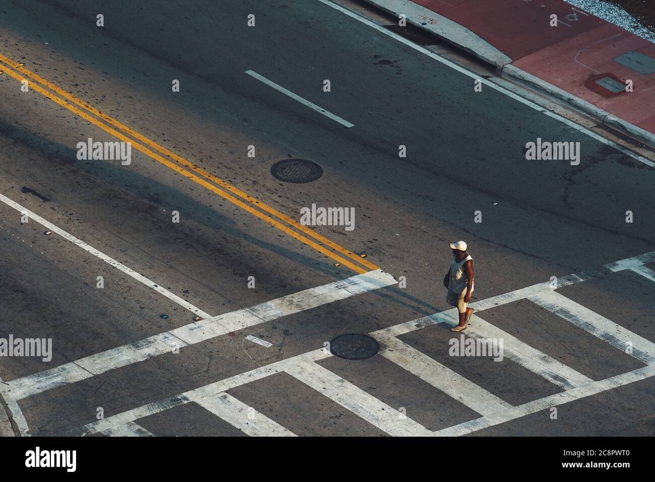 Pedestrian afro american man at crossroad  alone in Miami, aerial view Stock Photo