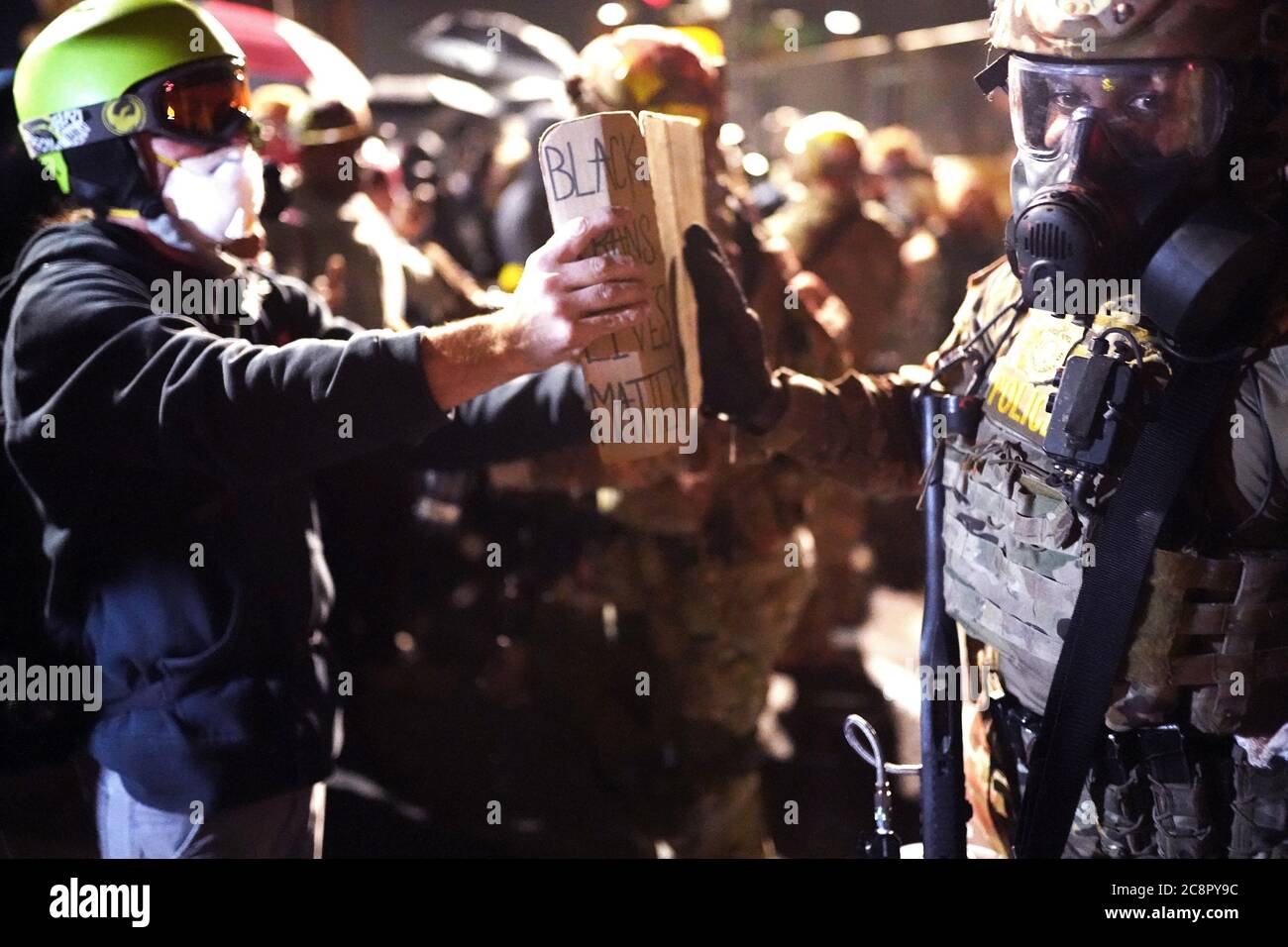 Portland, Oregon, USA. 26th July, 2020. A federal officer pushes away a protester's sign during a protest against racial injustice and police brutality in front of the Mark O. Hatfield U.S. Courthouse. Credit: Nathan Howard/ZUMA Wire/Alamy Live News Stock Photo