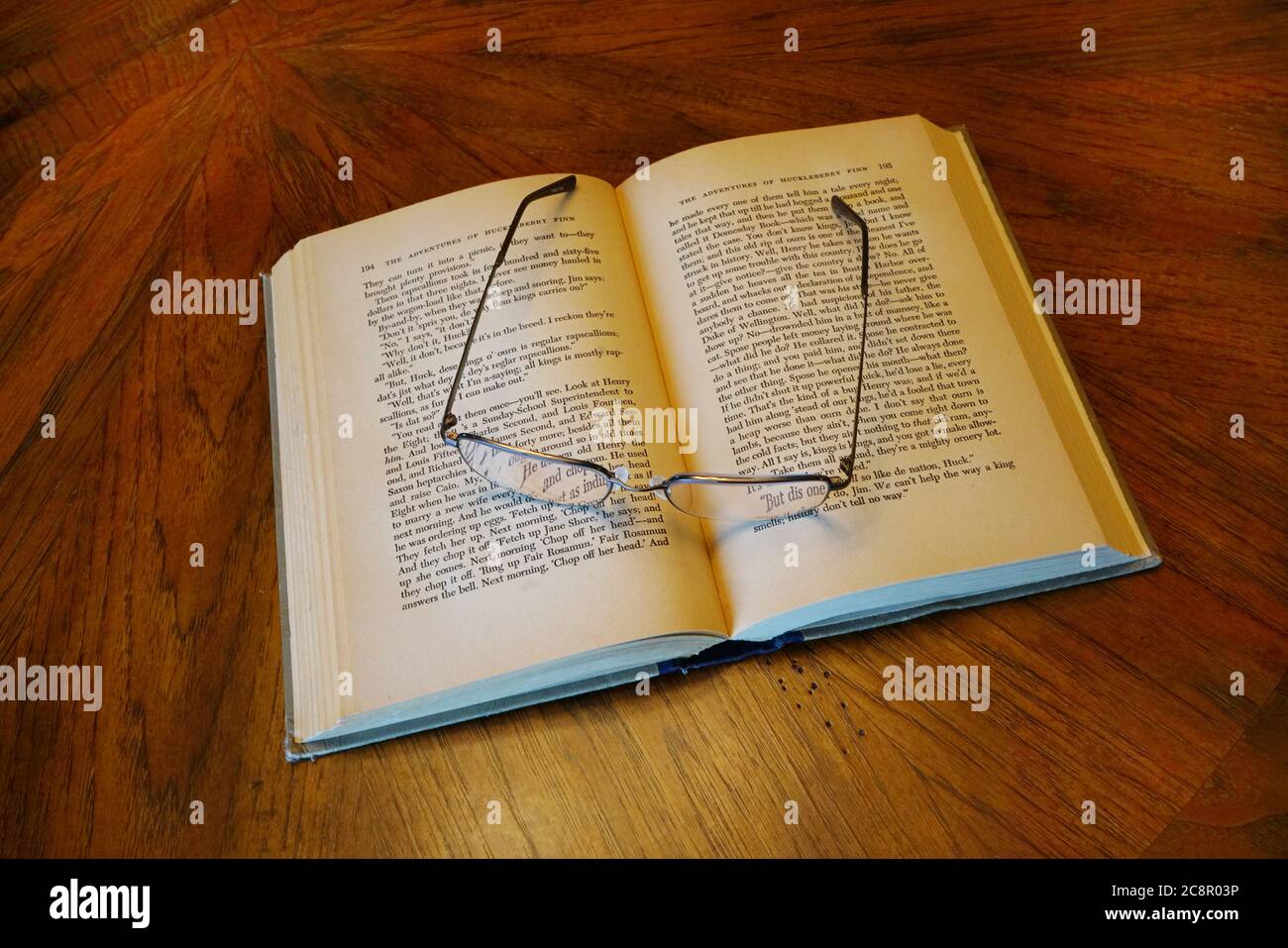 Vintage Book with reading glasses on wood table Stock Photo