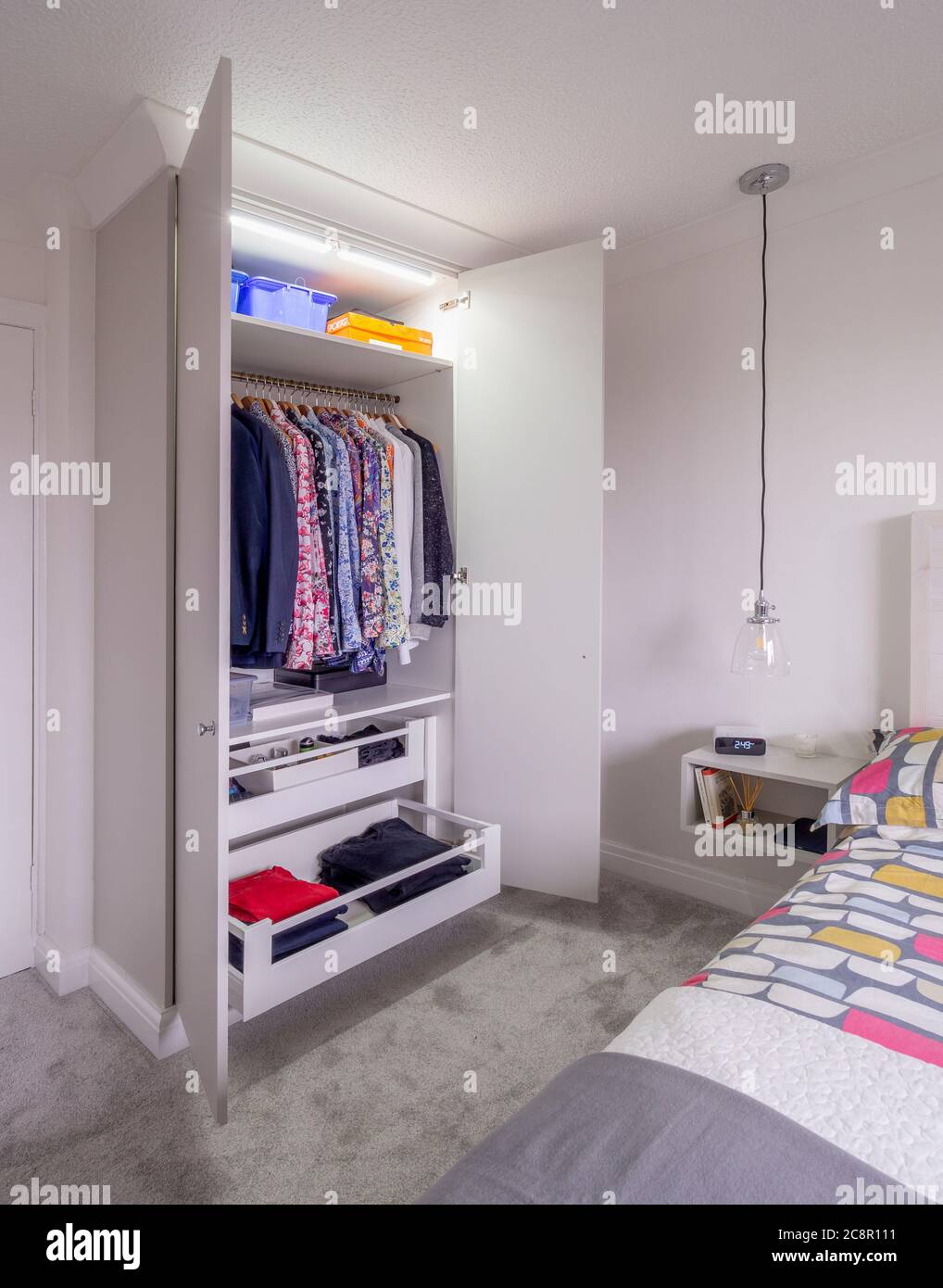Bedroom interior with open wardrobes showing clothes storage Stock Photo