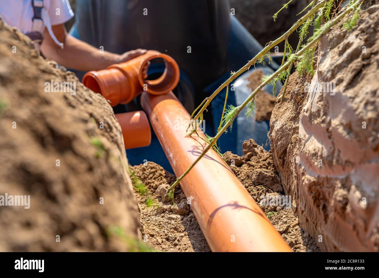 building a rainwater drainage to the collection container with the help of a plastic pipe Stock