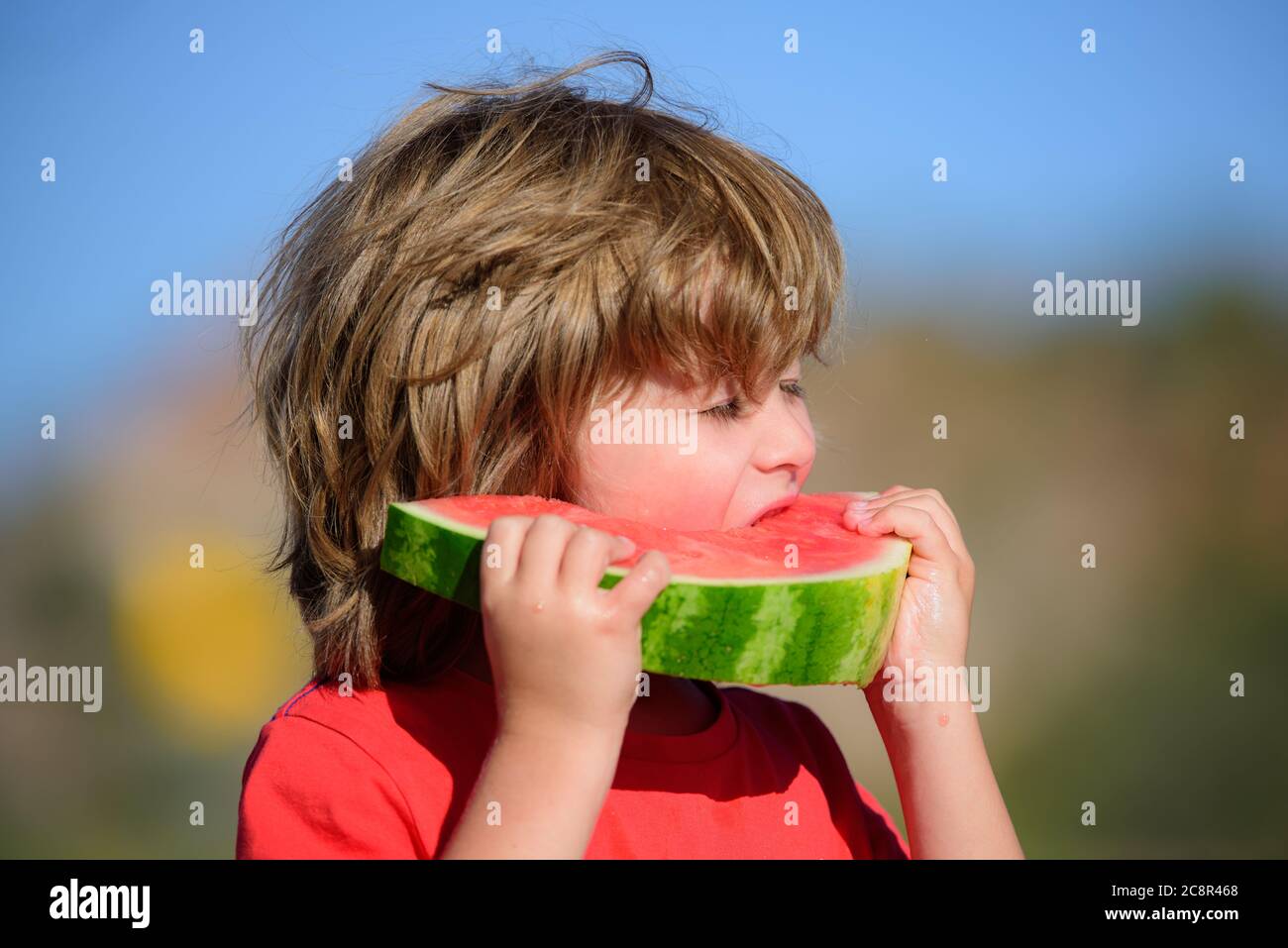 Kid eating watermelon outdoors. Healthy food for child. Stock Photo