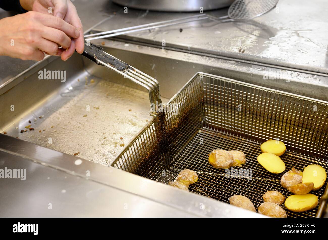 Preparing potatoes in deep fryer with boiling oil. High quality photo