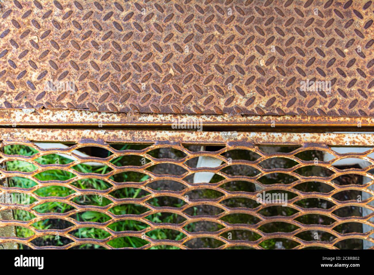 Metal rusty grill. Rustic lattice with rhombs or ovals pattern. Grate for cleaning shoes from metallic lines Stock Photo