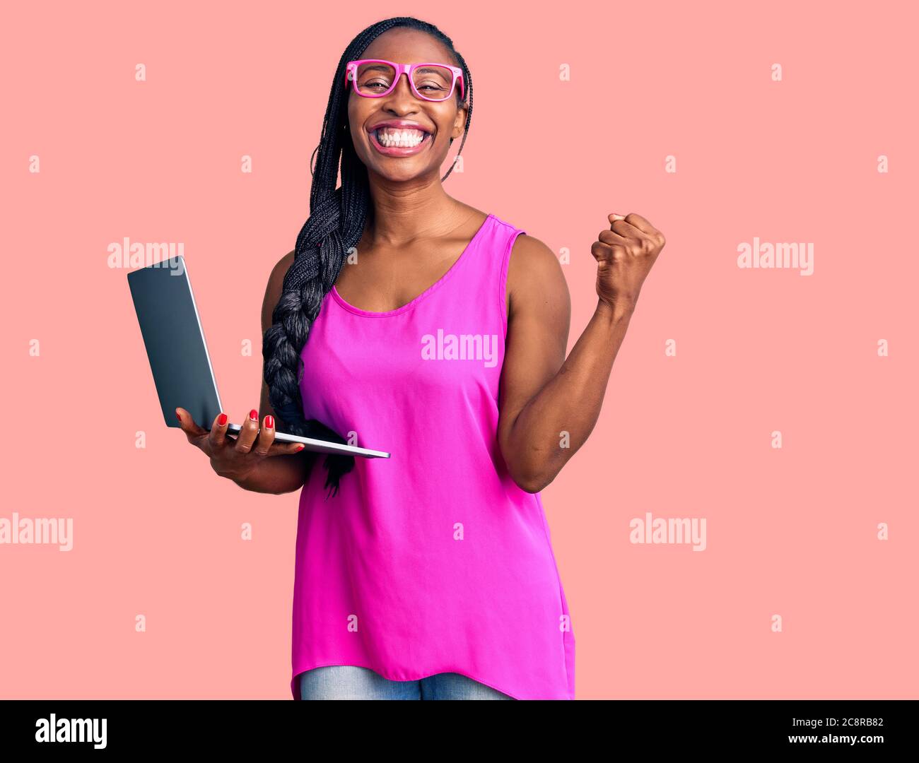Young african american woman working using computer laptop screaming ...