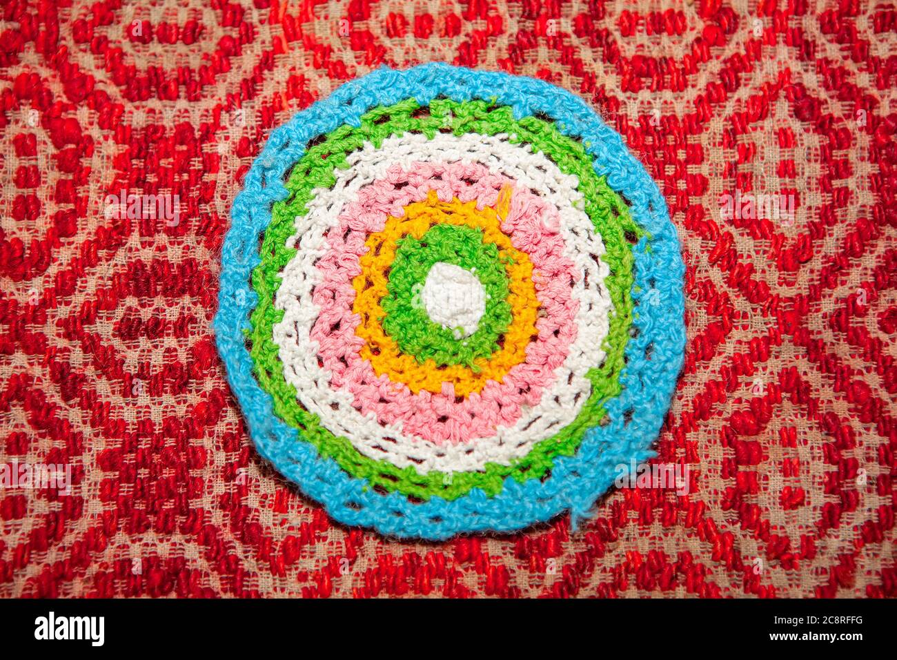 Embroidered rug in the shape of a circle . Handmade colorful carpet