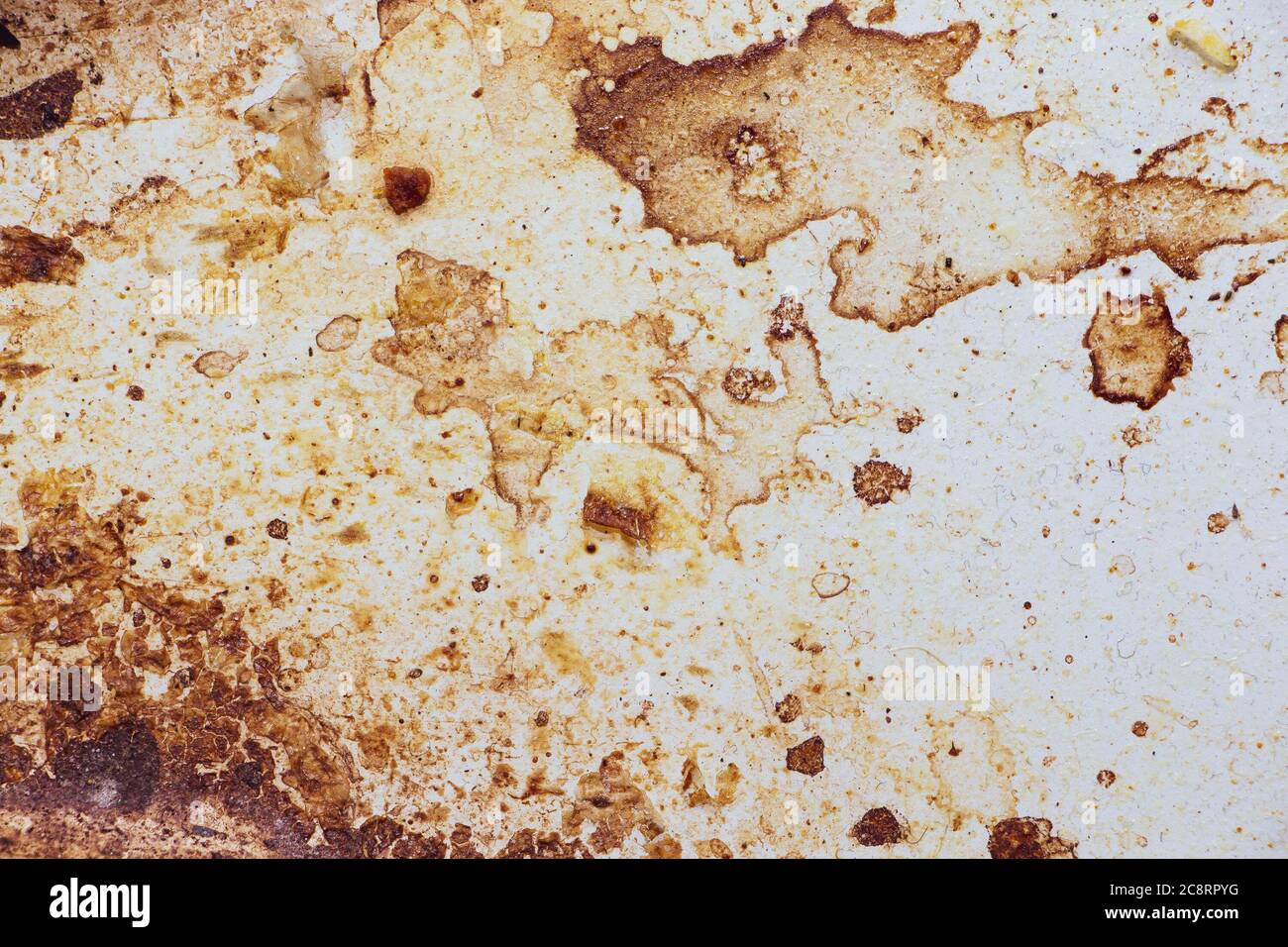 Texture of dirty stains and grease on white stove. Spots of fat on a