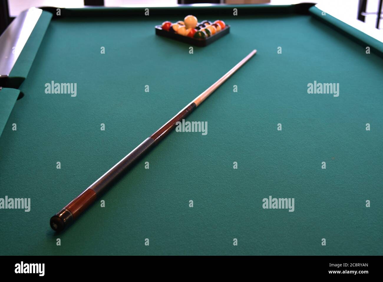 Pool cue on a green felt pool table Stock Photo