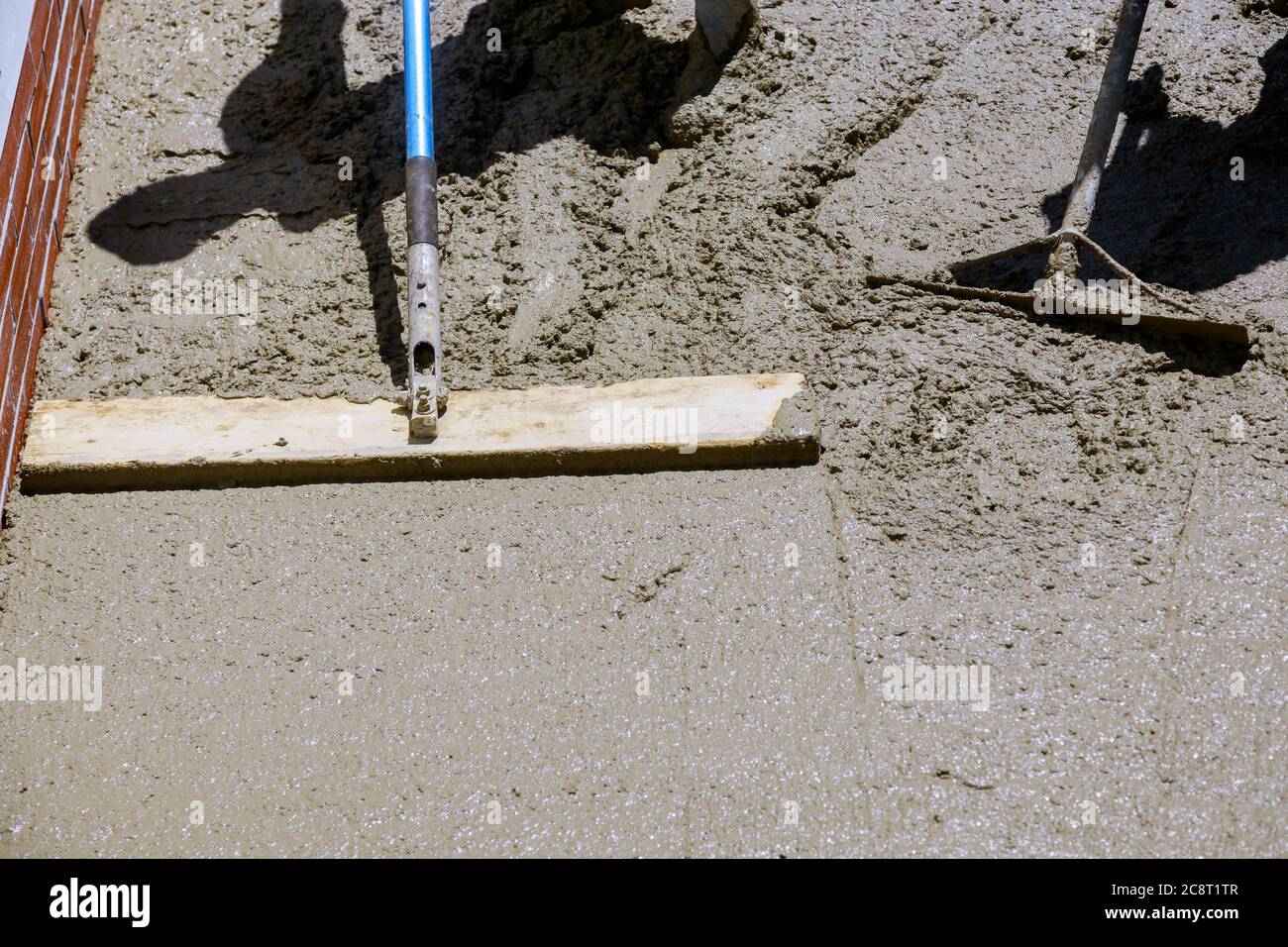 Construction filling formwork with cement and gravel worker pour cement for sidewalk in concrete
