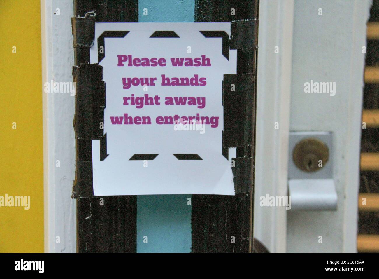 London, UK. 26th July, 2020. A sign outside a shop in Bricklane reminds customers to wash their hands on entering the premises.The Government has made it mandatory to wear face coverings in all public transport, supermarkets and indoor shopping centers as a measure to combat the spread of the novel coronavirus. Credit: SOPA Images Limited/Alamy Live News Stock Photo