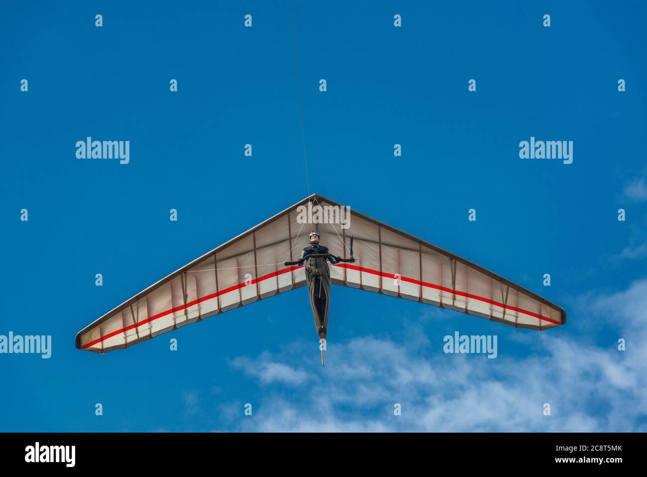 Bright hang glider wing silhouette from below. Extreme sport. Stock Photo