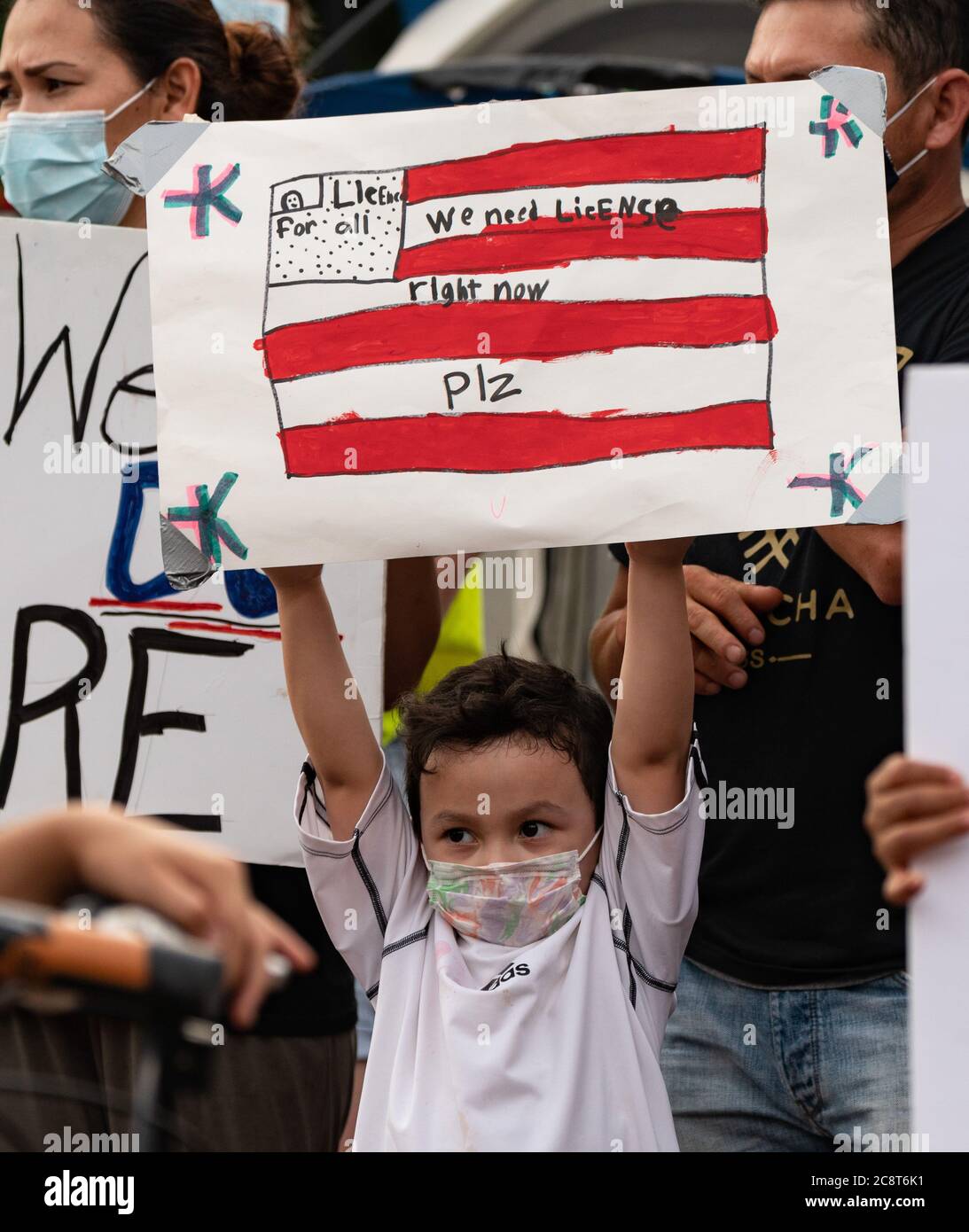 July 26, 2020, Boston, Massachusetts, USA: A child holds a sign 'we need license right now plz' during a rally with Black Lives Matter rally in front of Massachusetts Statehouse where immigration activists have been camping out to advocate driver's licenses for all qualified Massachusetts residences regardless of immigration status, for 11 days. Credit: Keiko Hiromi/AFLO/Alamy Live News Stock Photo