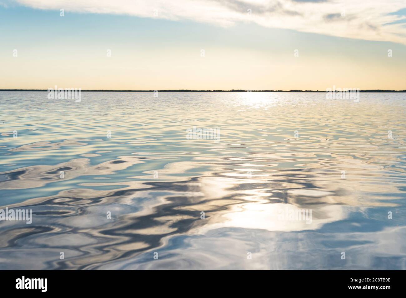reflected sun rays on sea water. Glare on the water in form of stars. Natural abstract sea water background. Stock Photo