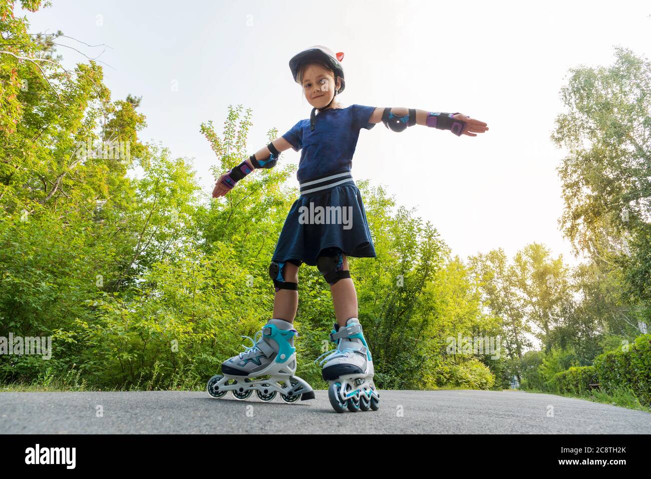 A child rides on roller skates with his arms outstretched against the