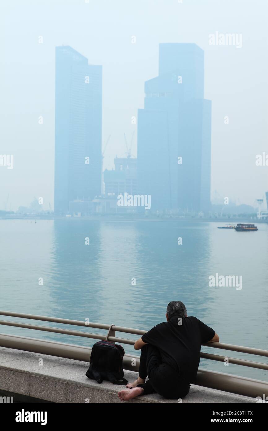 A man sitting outdoor in this hazy pollution and humid weather in Singapore, Southeast Asia