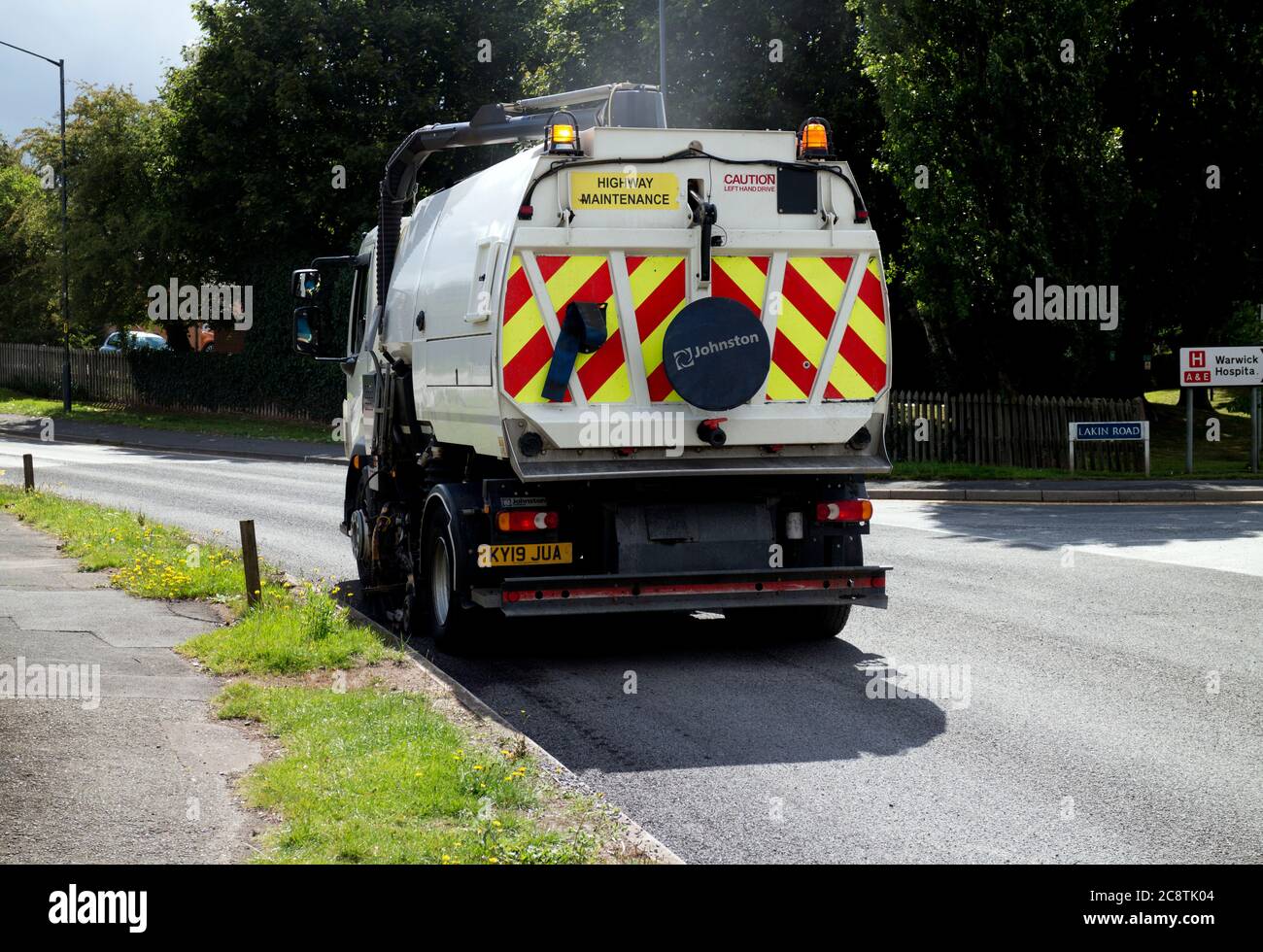 A road sweeper lorry clearing up loose chippings after road surfacing, Warwick, UK Stock Photo