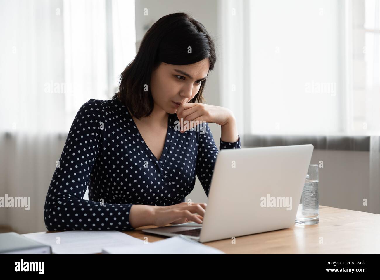 Pensive Asian woman work on laptop thinking Stock Photo - Alamy