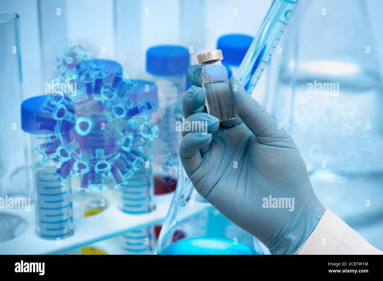 The scientist's hand holding the Covid-19 vaccine with blue gloves in the background of the biotechnology concept. Stock Photo