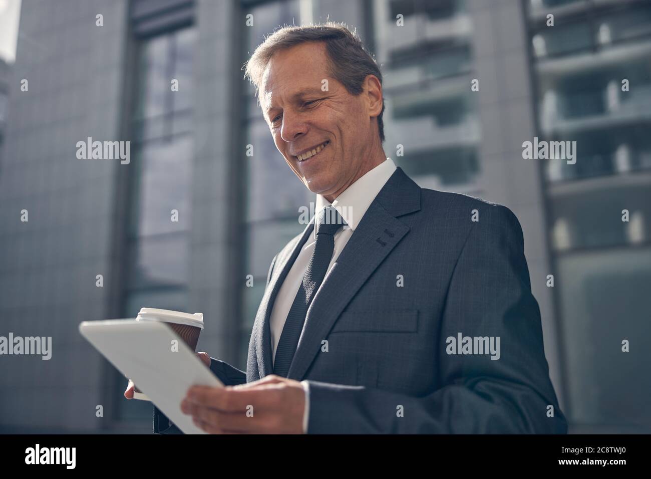 Cheerful man using tablet computer on the street Stock Photo
