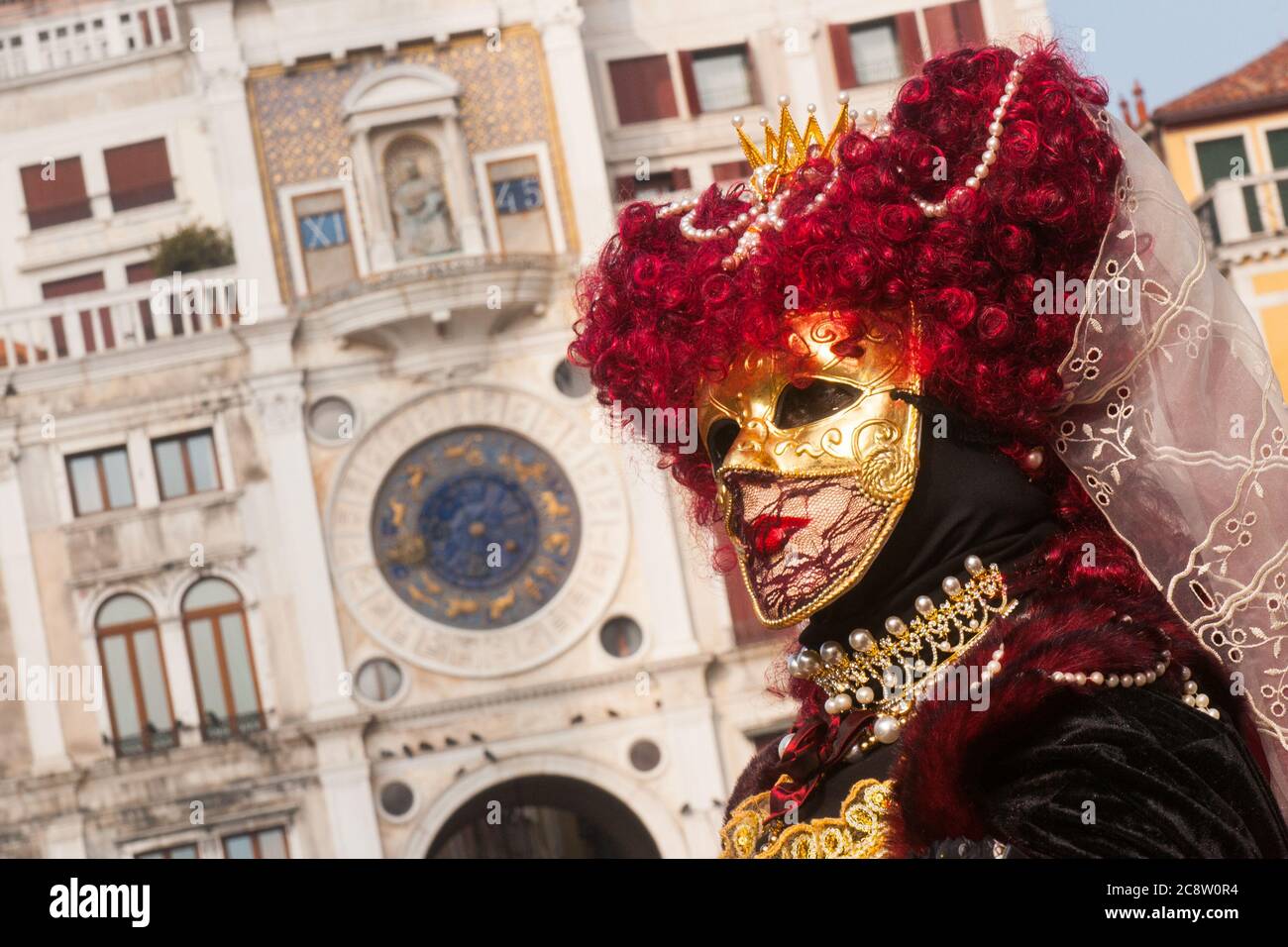 VENICE, ITALY - 28 FEBRUARY 2020: A beautiful mask in black and red costume poses during Venice Carnival Stock Photo