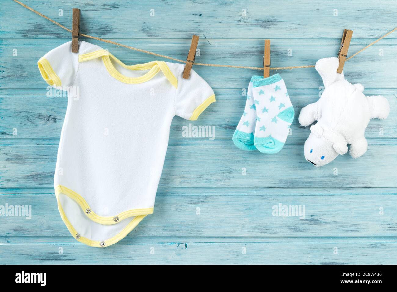 Baby clothes and white bear toy on a clothesline Stock Photo