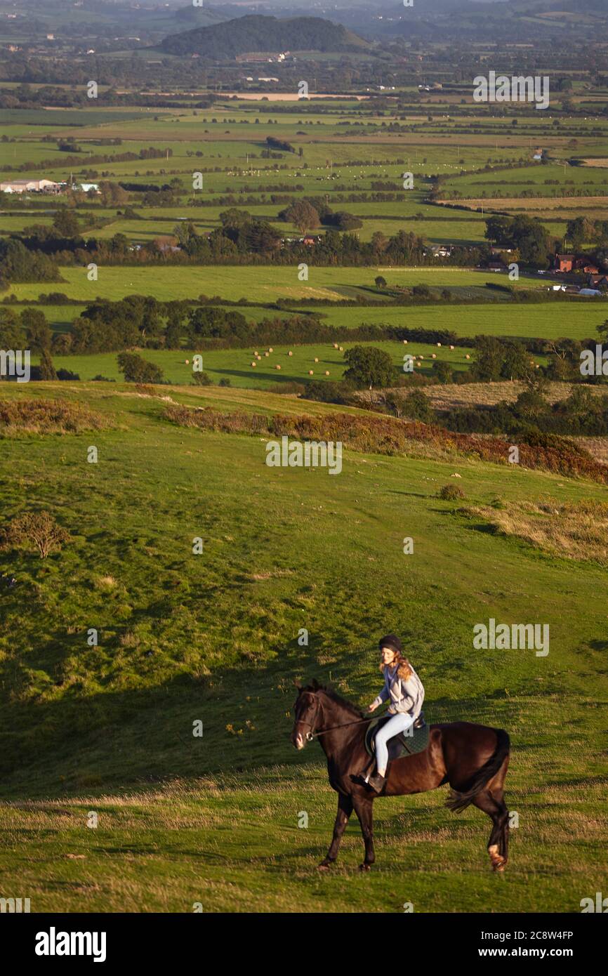 A horse rider on Crook Peak, in the Mendip Hills, with a view of the Somerset Levels beyond, Somerset, Great Britain. Stock Photo