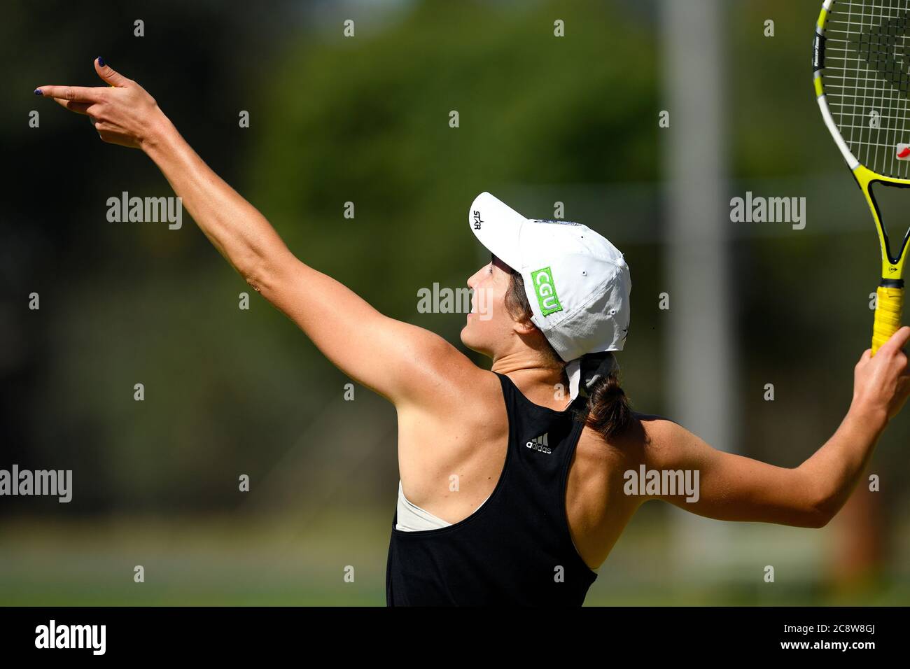 Grass roots sport. a young woman prepares to serve during a tennis match, Benalla, Victoria, Australia Stock Photo