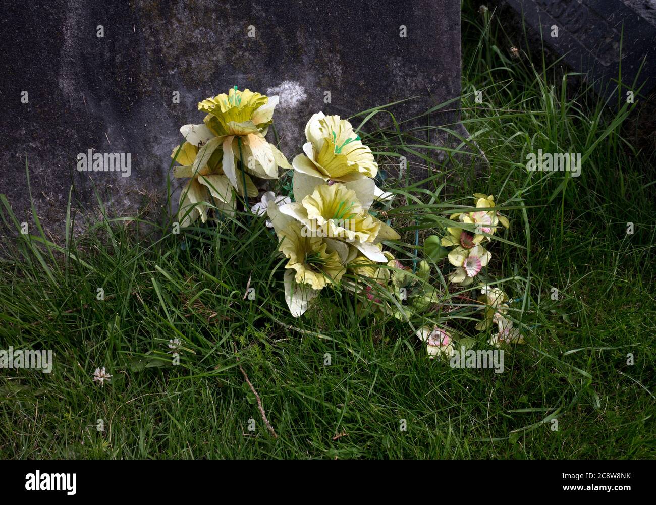 Artificial flowers on a grave, UK Stock Photo