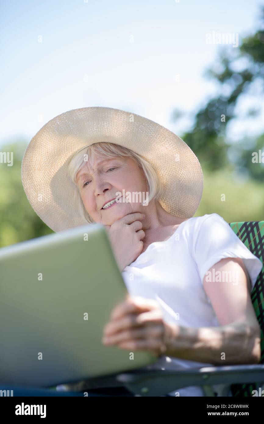 Thoughtful elderly woman having a rest with her computer Stock Photo